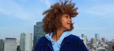 Portrait of a person in a city with buildings in the background, shot on the ZV-1 II