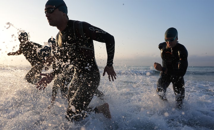 Example image of four triathletes coming out of the water