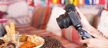 A usage image showing a user shooting a moroccan dish at the minimum focus distance of the lens