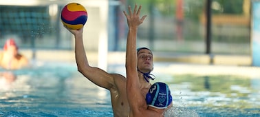 Example image showing a man trying to shoot the ball in a water polo game while another man in front defends by reaching out a hand, but focus is maintained on the man at the back