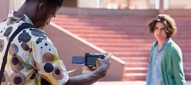 Usage image of a man holding the camera to film another man in an outdoor setting